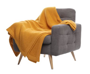 Beyaz üzerinde battaniyesi olan rahat bir koltuk.