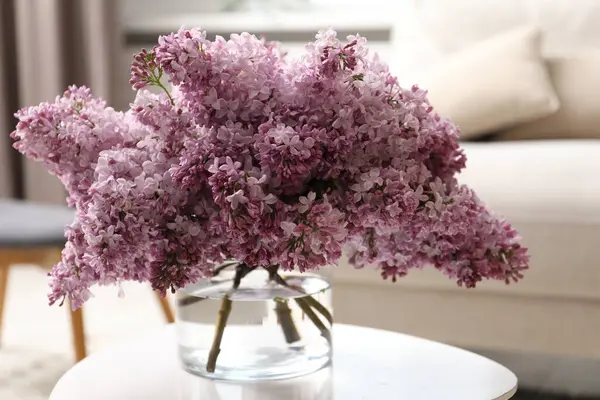 İçerideki masada vazoda güzel leylak çiçekleri.