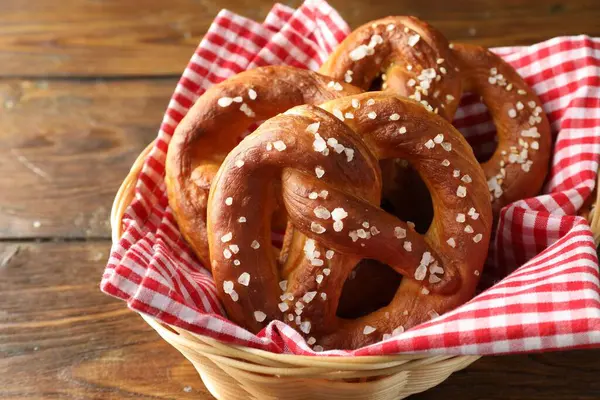 Hasır sepetteki tuzlu krakerler ahşap masada, yakın plan.