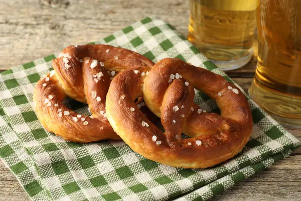 Lezzetli krakerler ve biralar ahşap masada, yakın plan.