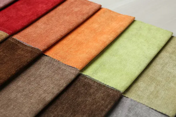 Açık ahşap masadaki farklı kumaşlardan örnekler.