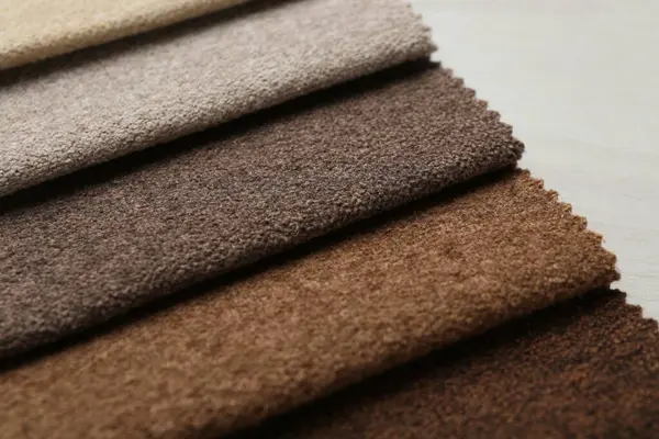 Açık ahşap masadaki farklı kumaşlardan örnekler.