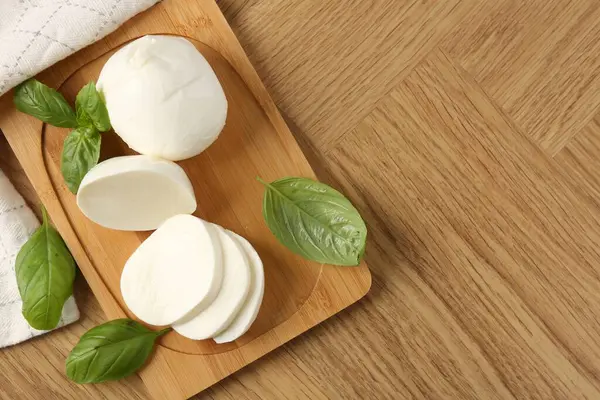 Lezzetli mozzarella ve fesleğen ahşap masada, düz yerde. Metin için boşluk
