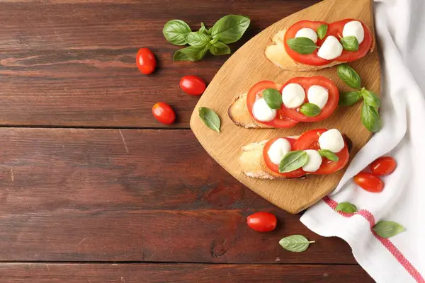 Peynirli, domatesli, ahşap masadaki fesleğenli lezzetli sandviçler. Metin için boşluk