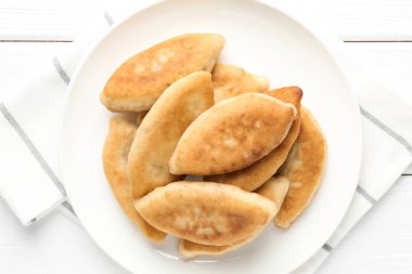 Lezzetli kızarmış pirizky (doldurulmuş turtalar) beyaz ahşap masa, üst görünüm