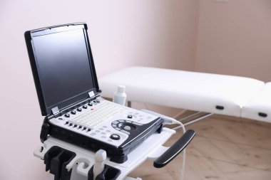 Modern ultrason makinesi ve klinikte muayene yatağı