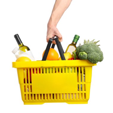 Beyaz arka planda farklı ürünleri olan alışveriş sepeti tutan adam, yakın plan.