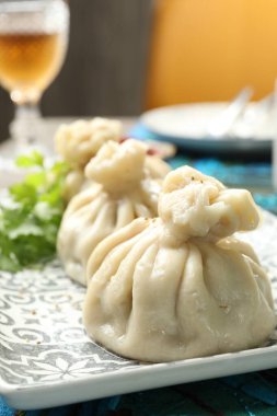 Lezzetli pişmiş khinkali masada servis ediliyor, yakın plan.