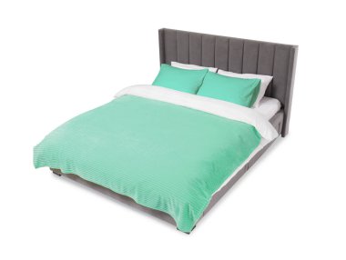 Beyaz arka planda güzel çarşaflarla yapılmış bir yatak.