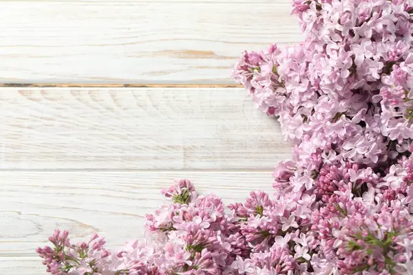 Açık ahşap masada güzel leylak çiçekleri, yakın plan. Metin için boşluk