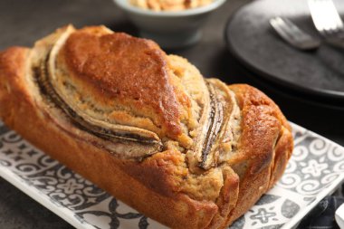 Gri masada servis edilen lezzetli muzlu ekmek, yakın plan.