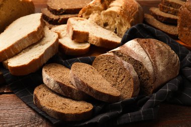 Tahta masadaki farklı taze ekmek türleri, yakın çekim.