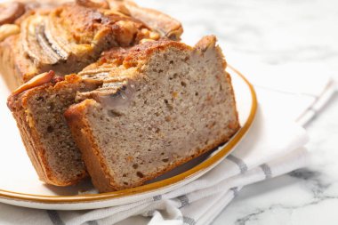 Beyaz mermer masada fındıklı muz ekmeği kes, yakın plan.