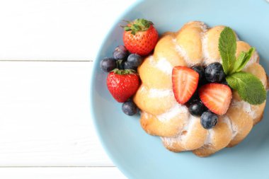 Beyaz ahşap masada pudra şekeri ve böğürtlenli Lezzetli kek, üst manzara. Metin için boşluk