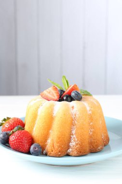 Beyaz ahşap masada pudra şekeri ve böğürtlenli Lezzetli kek, yakın plan. Metin için boşluk