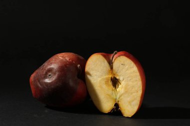 Siyah arka planda zarar görmüş kırmızı elmalar. Metin için boşluk