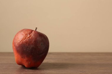 Ahşap masada bir çürük kırmızı elma. Metin için boşluk