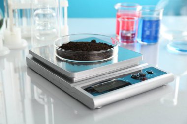 Beyaz ayna masasındaki Petri kabı ve diğer cam parçalarıyla açık mavi arkaplanı tart, kapat