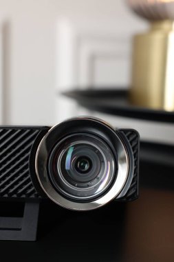 Modern video projektörü siyah masada kapalı, yakın plan
