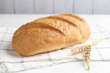 Taze ekmek somunu ve çiviler beyaz ahşap masada, yakın plan.