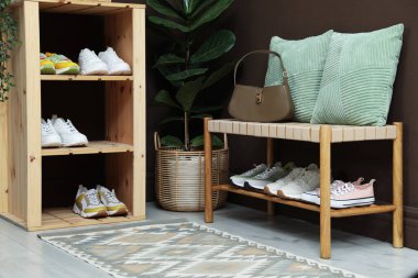 Girişteki raflarda farklı ayakkabılar var. Ayakkabı deposu