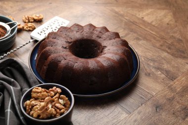 Lezzetli çikolatalı kek, ceviz ve kakao tozu ahşap masada, yakın plan. Metin için boşluk