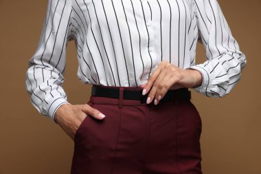 Kahverengi arka planda kendine güvenen iş kadını, yakın plan.