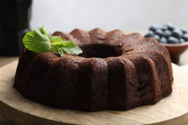 Naneli çikolatalı kek ve ahşap masada yaban mersini, yakın plan.