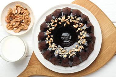 Fındıklı çikolatalı kek ve beyaz ahşap masada bir bardak süt.