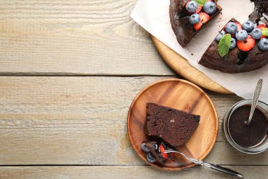 Çilekli, nane ve böğürtlenli, ahşap masada servis edilen lezzetli çikolatalı kek. Metin için boşluk