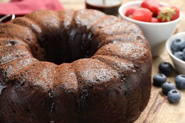 Ahşap masada yaban mersinli lezzetli çikolatalı kek, yakın plan.