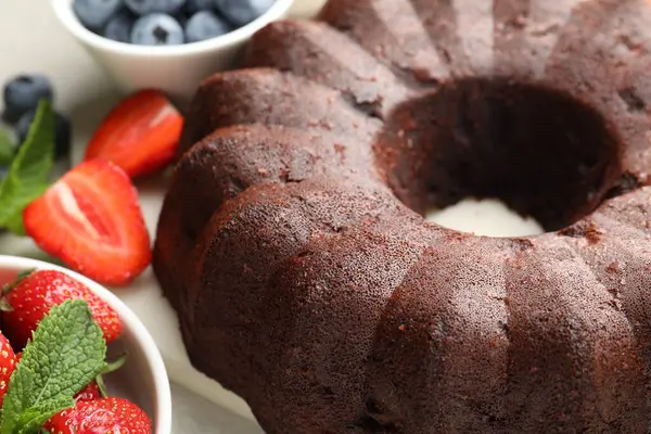 Çikolatalı kek ve böğürtlenler ışık masasında, yakın plan.