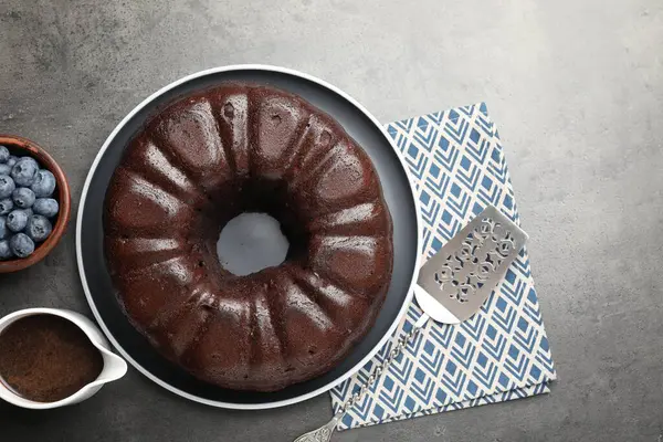 Lezzetli çikolatalı kek, yaban mersini ve sunucu gri masada.