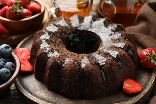 Lezzetli çikolatalı kek, cila, çay ve böğürtlen ahşap masada, yakın plan.