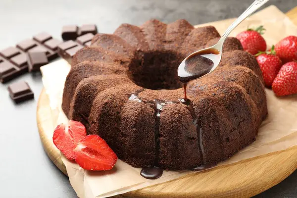 Masadaki çikolatalı kekin üzerine cila dök, yakın plan.