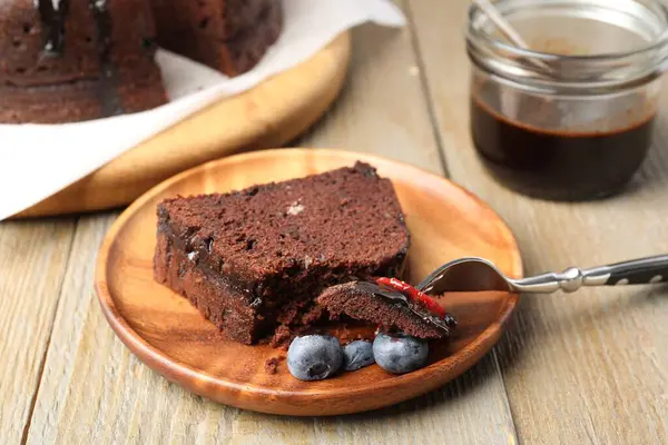 Bir parça lezzetli çikolatalı kek, ahşap masada yaban mersini, yakın plan.