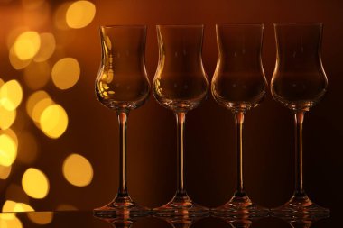 Bulanık ışıklara karşı cam ayna yüzeyinde birçok temiz bardak var. Bokeh etkisi