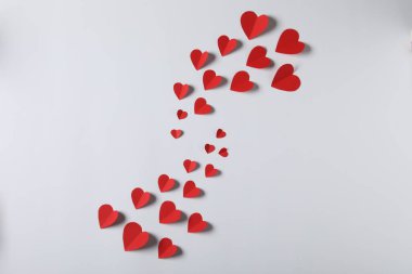 Açık gri arkaplanda bir sürü kağıt kalp var.