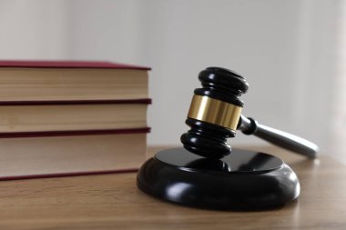 Yargıç tokmağı ve kitaplar kapalı bir masa üzerinde, yakın plan.