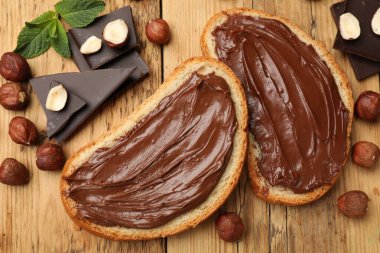 Lezzetli fındıklı tostlar, çikolata parçaları ve fındıklar ahşap masada, düz yatıyordu.