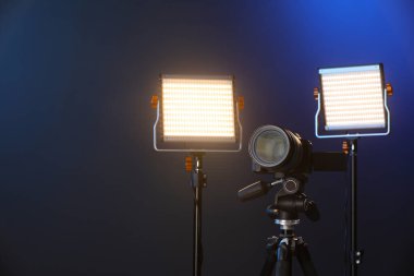 Renkli arka planda profesyonel ışıklandırma ekipmanı ve kamera