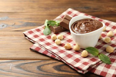 Lezzetli çikolata, parçalar, nane ve fındıklar ahşap masada, yakın plan. Metin için boşluk