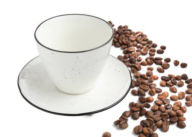 Beyaz üzerine izole edilmiş kavrulmuş kahve çekirdekli seramik fincan.