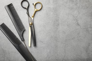 Gri masadaki farklı kuaför aletleri, düz yatış. Metin için boşluk