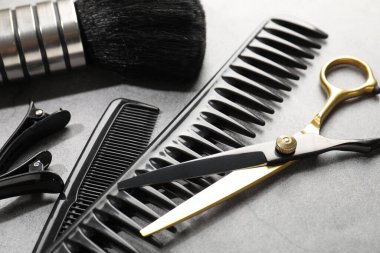 Gri masadaki farklı kuaför aletleri, yakın plan.