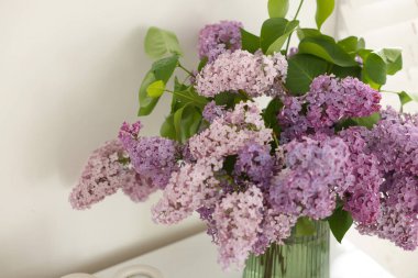 İçerideki masada vazoda güzel leylak çiçekleri, yakın plan.