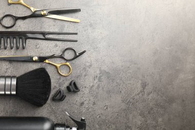 Gri masadaki farklı kuaför aletleri, düz yatış. Metin için boşluk