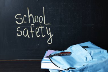 Sırt çantasında kitap, defterler ve kara tahtanın yanındaki siyah ahşap masada bıçak var. Okul güvenliği