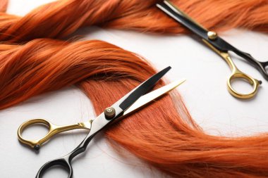 Hafif arkaplanda saç teli ve makas, yakın plan.