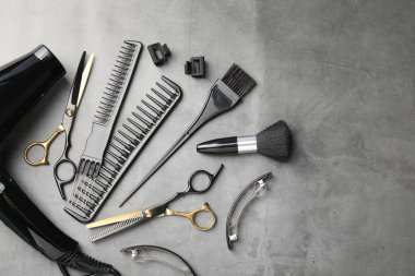 Gri masadaki farklı kuaför aletleri, düz yatış. Metin için boşluk